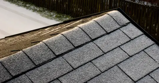 light snow and icicles in shingle roof